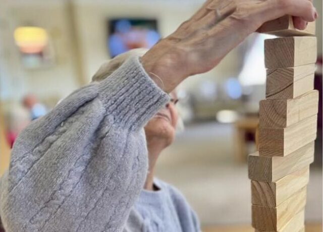 a senior lady playing jenga